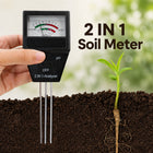 Hand holding soil pH and fertility meter with a seedling