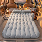 Car air mattress set up for camping, with lanterns in background