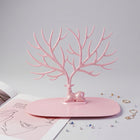Front view of pink deer jewelry stand with earrings and rings, India