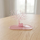 Base view of pink deer jewelry stand on table, India