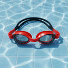 Detailed look at red swimming goggles emphasizing anti-fog lenses