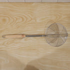 Cooking strainer utensil with long wooden handle for efficient frying