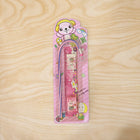 Pink stationery set displayed in use, showing ruler, pencil, eraser, and sharpener.