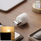Yellow USB LED night light plugged into a USB port illuminating warm ambient glow
