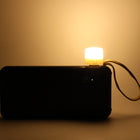 Close-up of warm yellow USB LED night light on a laptop keyboard